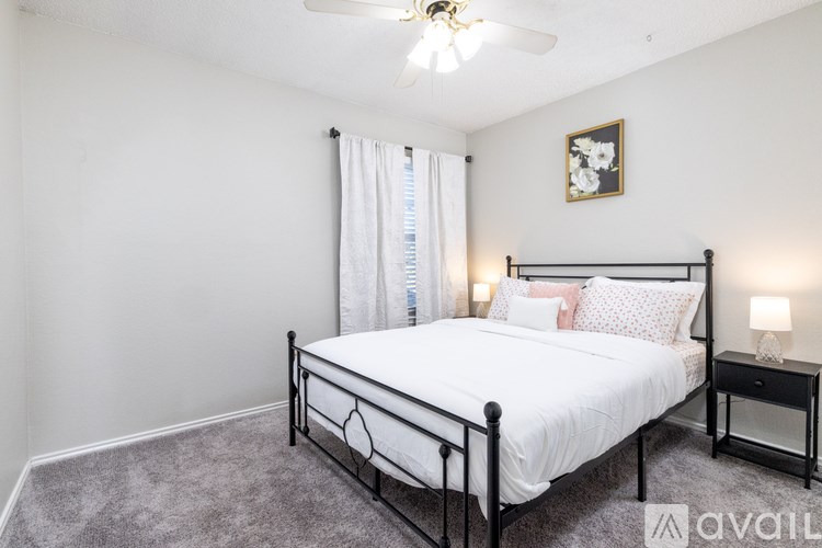A bedroom with a large bed and a ceiling fan.