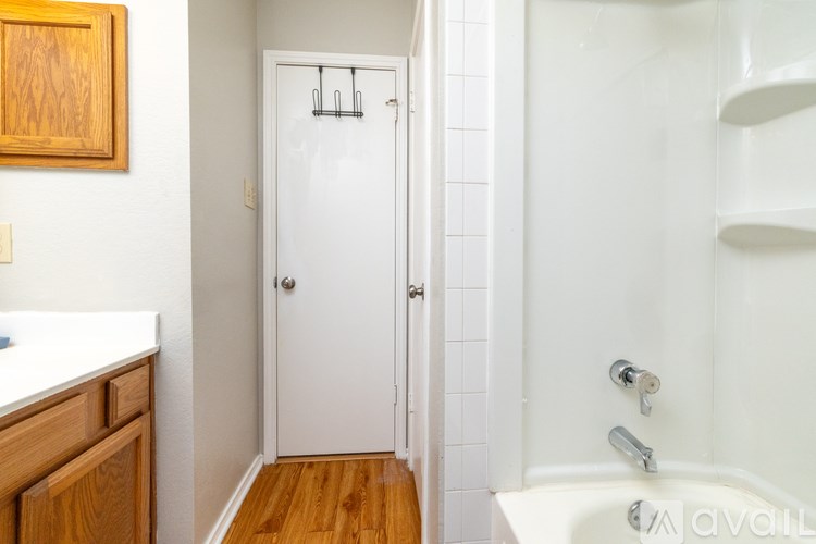 A white door with a silver handle is in a bathroom.
