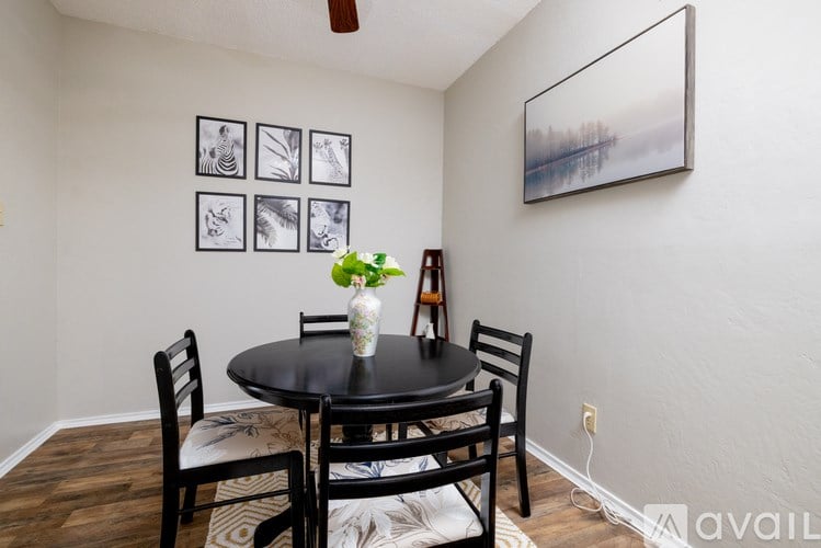 A dining room with a table, chairs, and pictures on the wall.