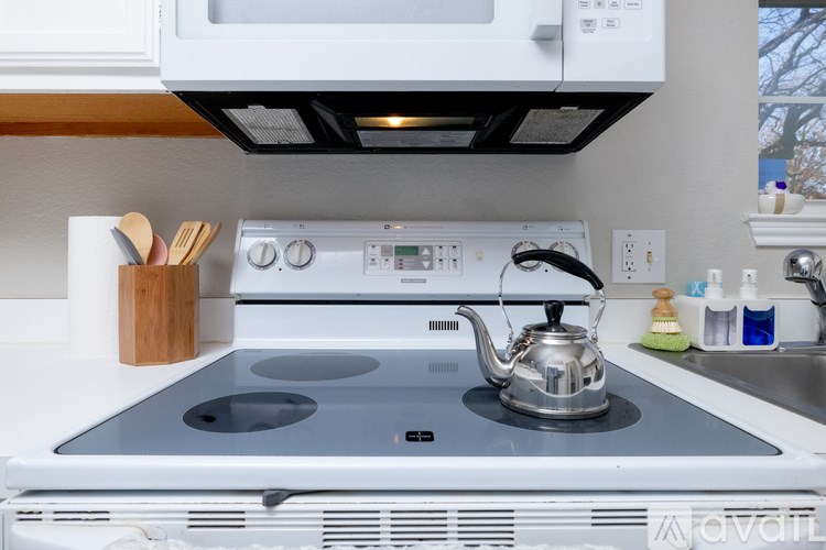 A white stove top with a kettle on it.