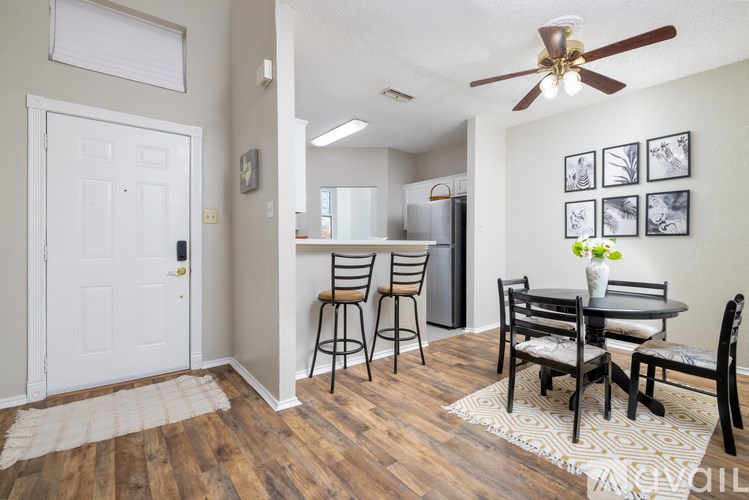 A dining room with a white door and a white ceiling fan.