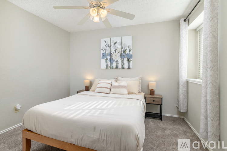 A bedroom with a large bed and a ceiling fan.