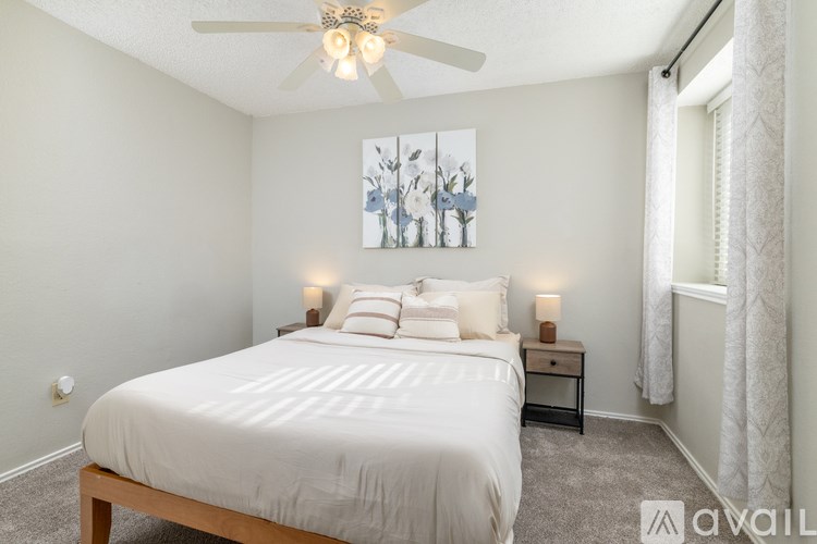 A bedroom with a large bed and a ceiling fan.