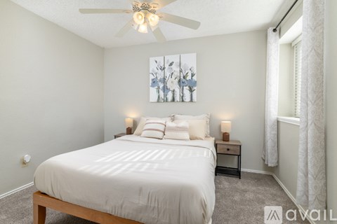 A bedroom with a large bed and a ceiling fan.