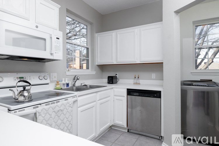 A kitchen with white cabinets and appliances.