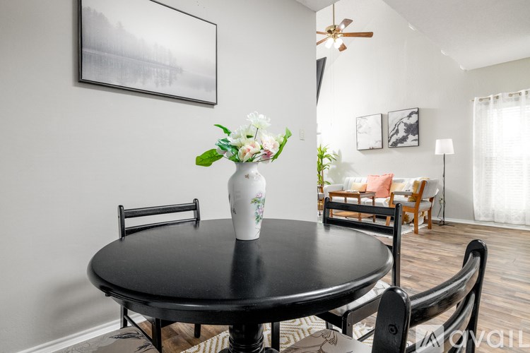 A black table with a vase of flowers on it.