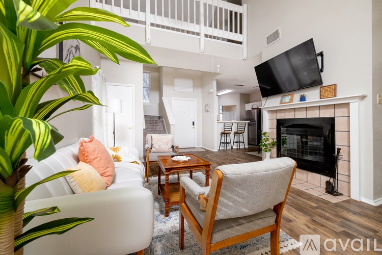 A living room with a fireplace and a television on the wall.