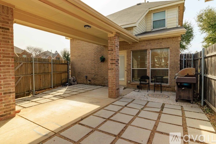 A patio area with a BBQ grill and a table.