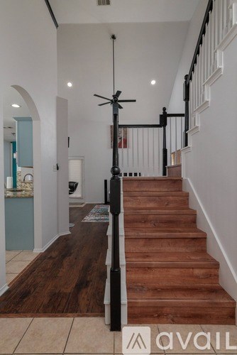 A staircase with a black railing and wooden steps.
