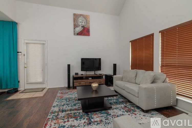 A living room with a couch, a coffee table, and a television.