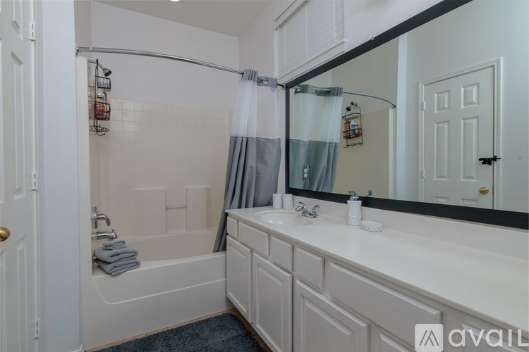 A bathroom with a white tub and sink.
