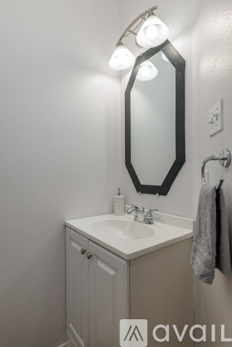 A bathroom with a sink, mirror, and lights.