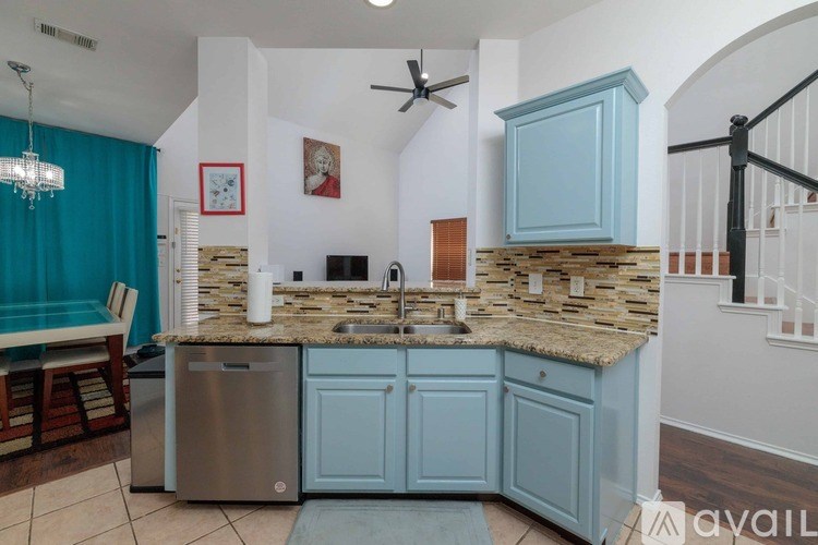 A kitchen with a blue cabinet and a stone backsplash.
