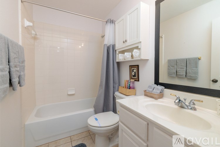 A bathroom with a white toilet, a white sink, a white bathtub, and a white cabinet.