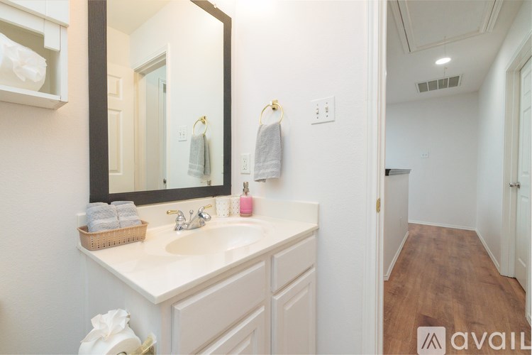 A bathroom with a white counter and a mirror.