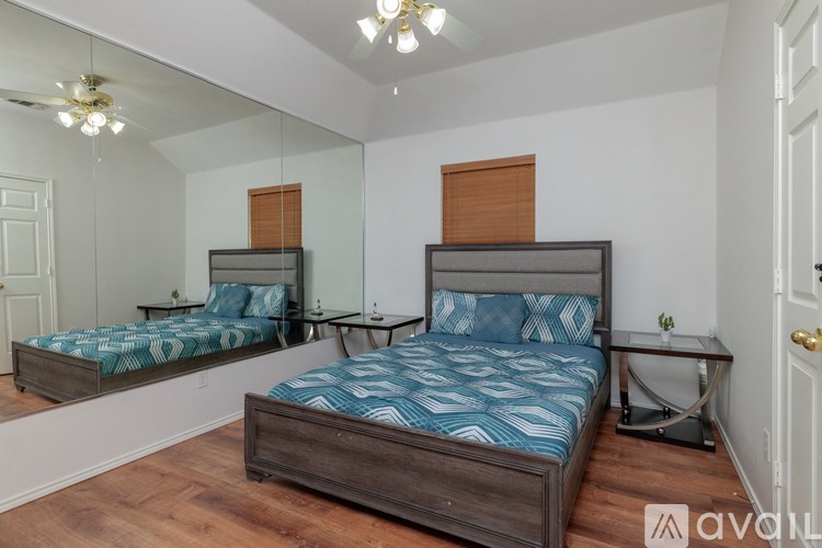 A bedroom with two beds and a mirror on the wall.