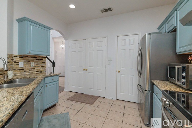 A kitchen with blue cabinets and a granite countertop.
