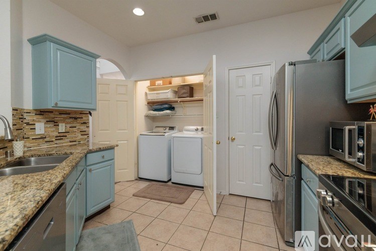A kitchen with a sink, refrigerator, and microwave.