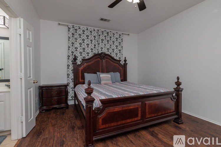 A bedroom with a large bed and a wooden dresser.