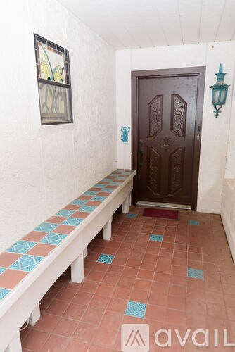 A hallway with a bench and a door.