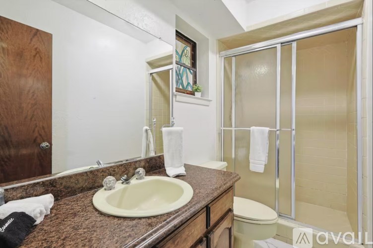 A bathroom with a brown countertop and a white sink.