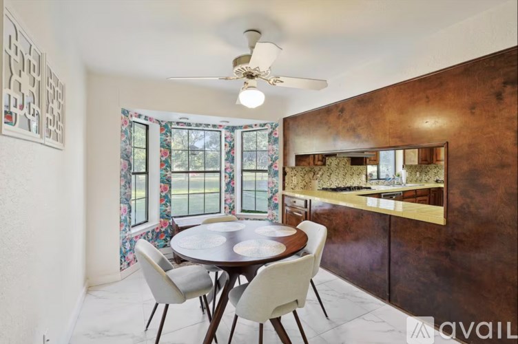 A dining room with a round table and chairs.