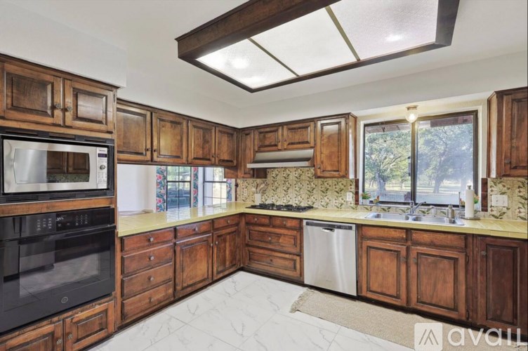 A kitchen with wooden cabinets and a black oven.