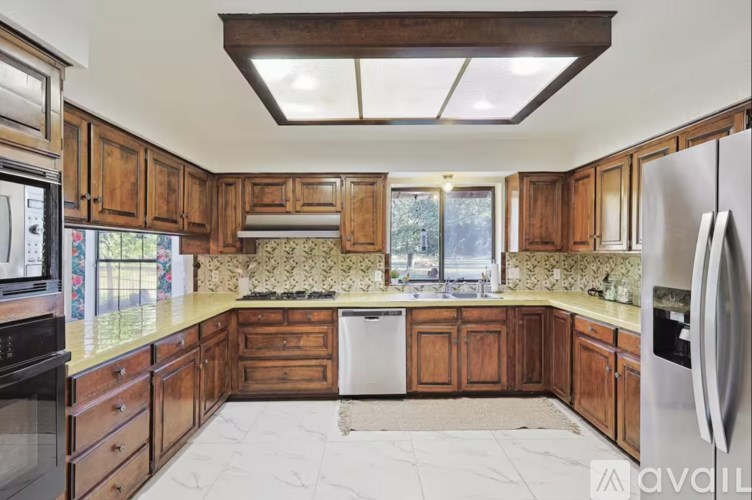 A kitchen with wooden cabinets and a marble countertop.
