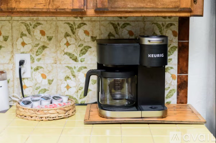 A Keurig coffee maker sits on a wooden coaster.