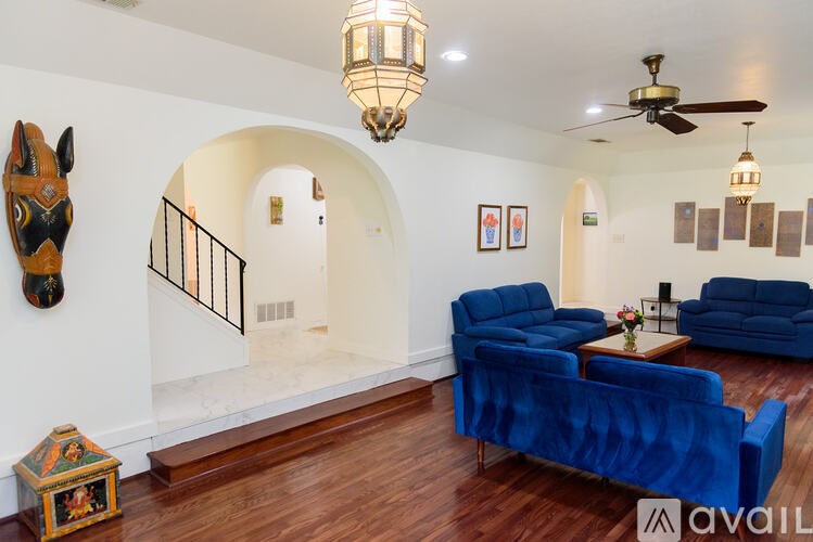 A living room with a blue couch and a wooden floor.