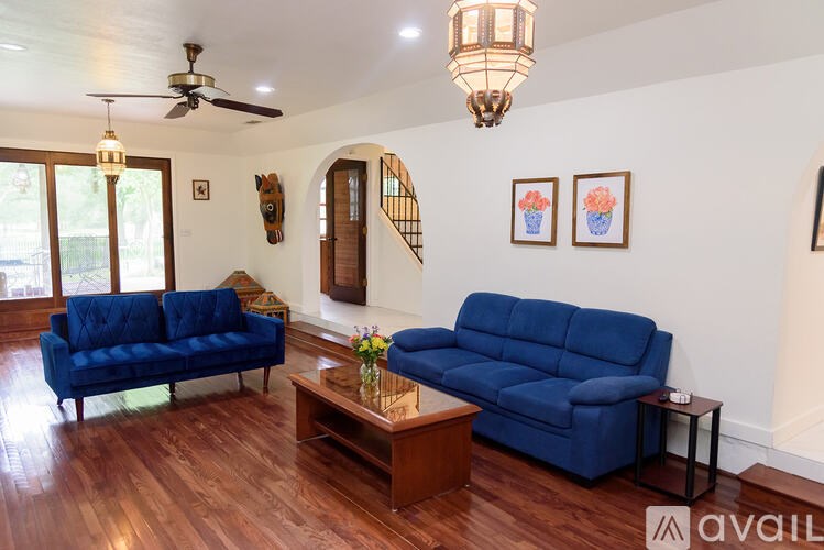 A living room with a blue couch and wooden floors.