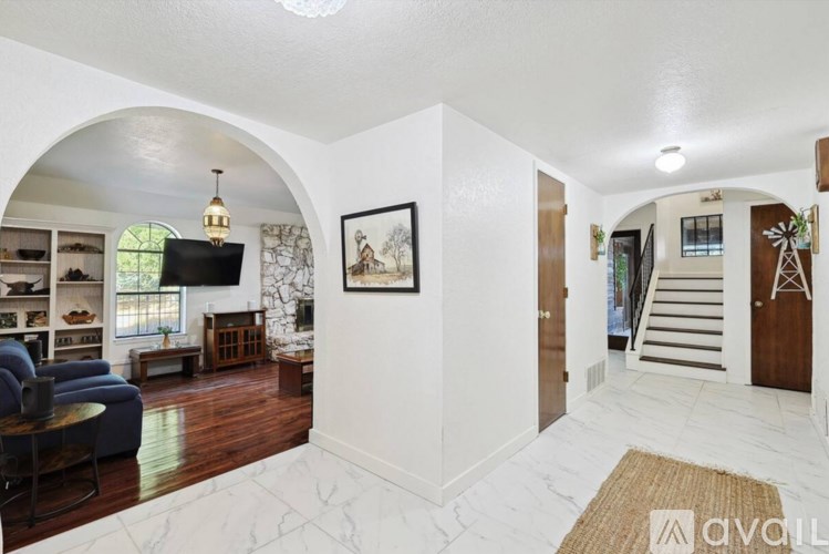 A living room with a blue sofa and a painting on the wall.