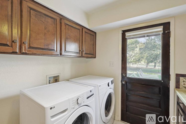 A white dryer and washer are sitting next to each other in a small laundry room.