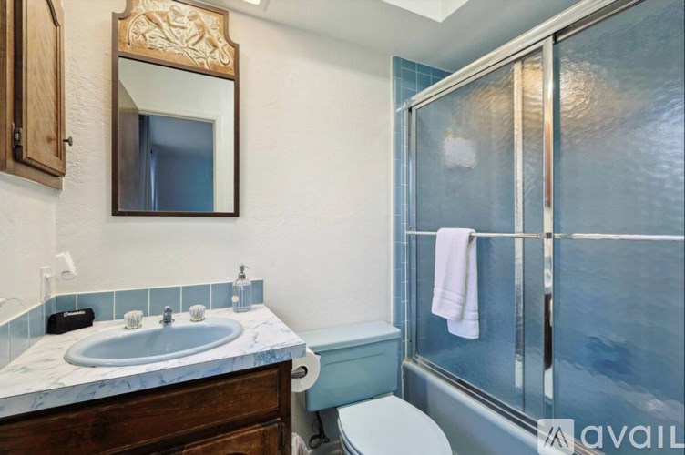 A bathroom with a marble countertop and a large mirror above the sink.