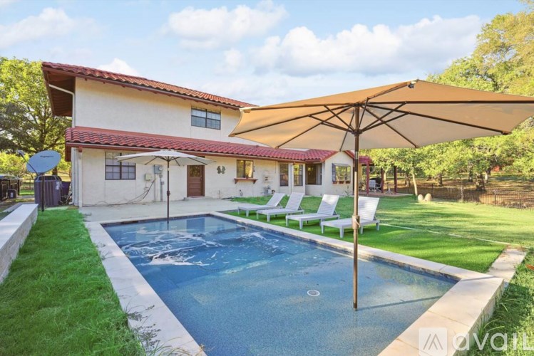 A house with a pool and a patio umbrella.