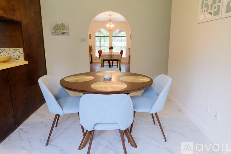 A dining room with a round table and blue chairs.
