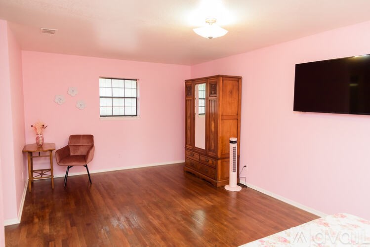 A room with a brown chair, a wooden cabinet, and a white floor lamp.