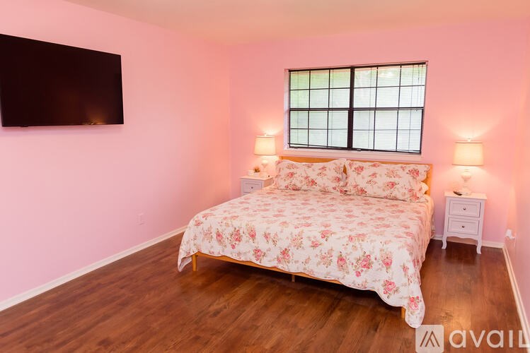 A bedroom with a bed, nightstands, and a window.