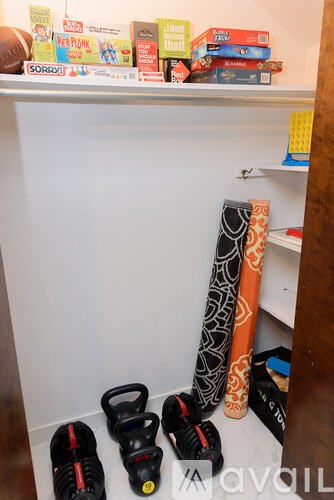 A pair of black and red shoes are on the floor next to a pair of black and yellow shoes.