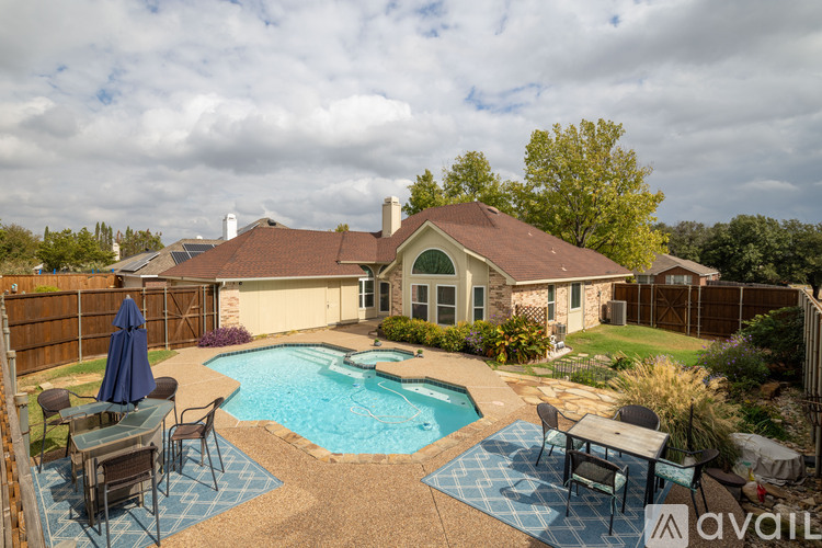 A backyard with a pool and patio furniture.