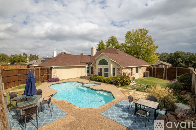 A backyard with a pool and patio furniture.