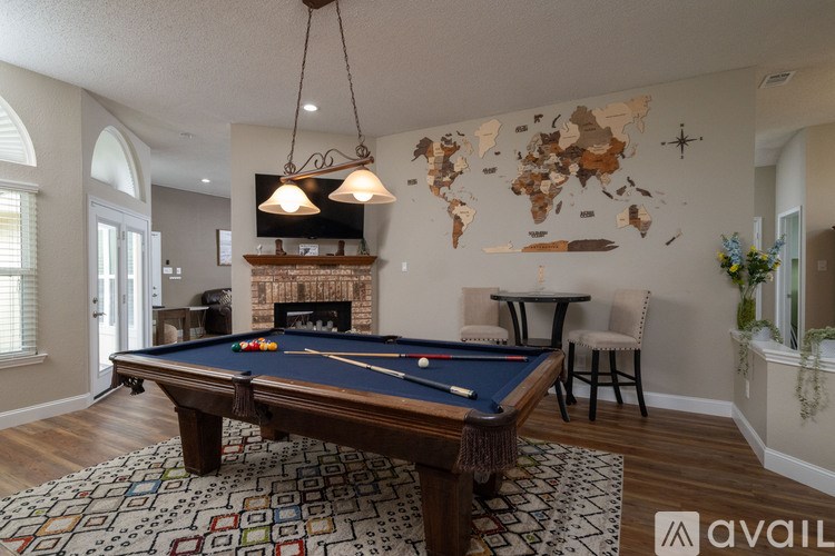 A pool table in a room with a world map on the wall.