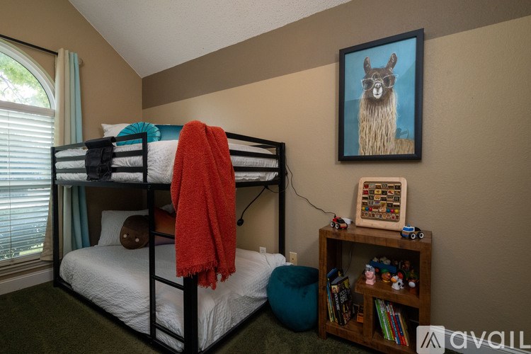 A bedroom with a bunk bed and a llama painting on the wall.