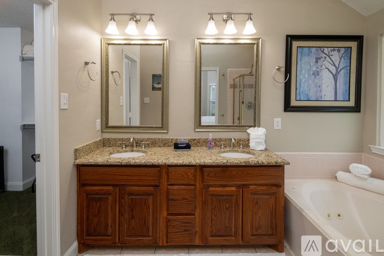 A bathroom with a granite countertop and a large mirror above it.