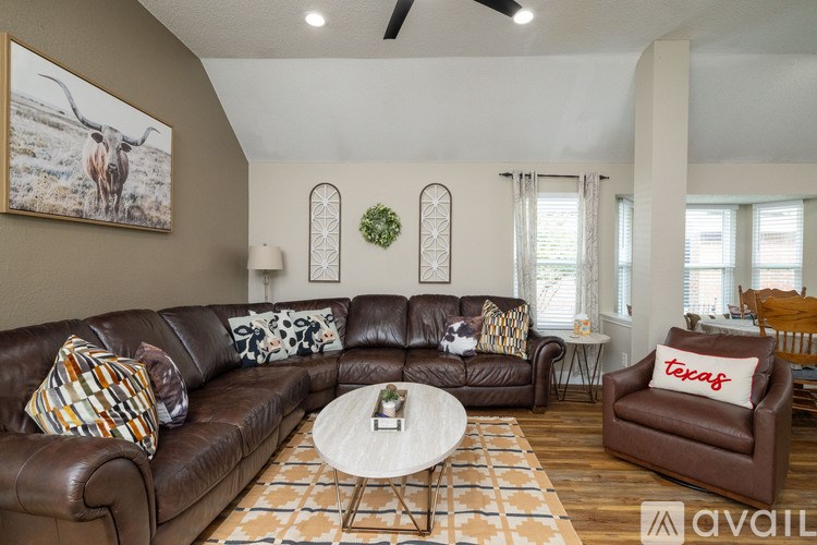 A living room with a brown leather couch and a coffee table.
