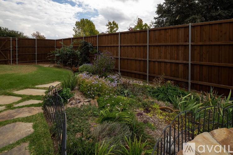 A garden with a fence and a stone path.