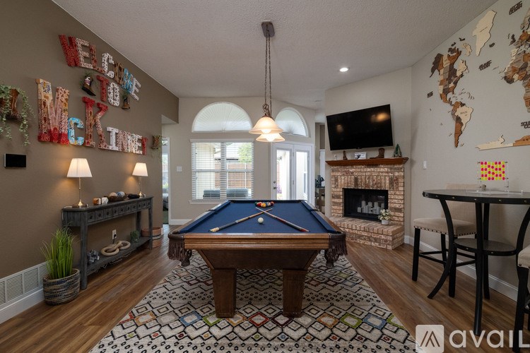 A pool table is in the middle of a room with a world map on the wall.