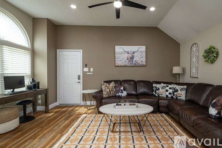 A living room with a brown leather couch and a white coffee table.
