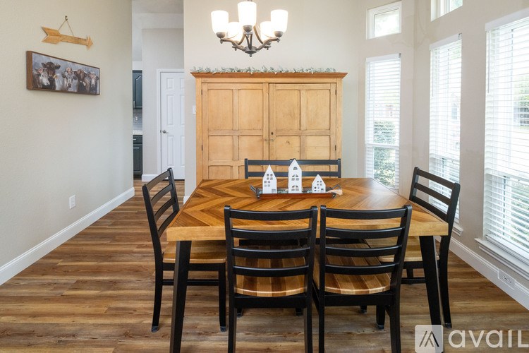 A dining room with a wooden table and chairs.