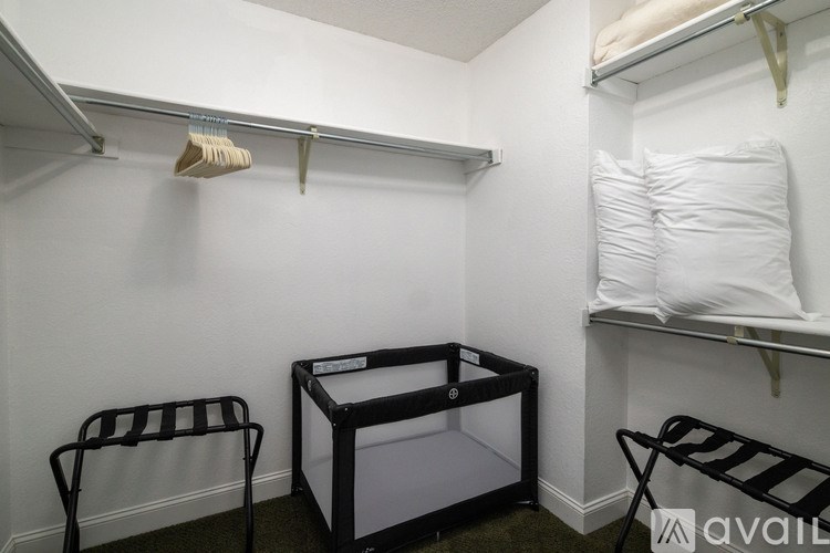 A small room with a clothes dryer and two chairs.